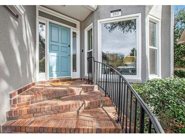 Charming entrance featuring a light blue front door, brick steps and a black metal railing at 883 Heritage Pl, Decatur, GA 30033