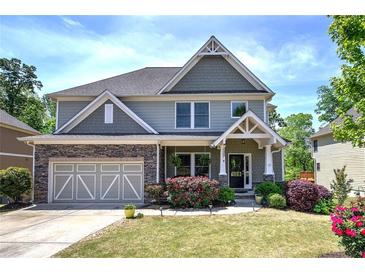 Charming two-story home featuring a stone-accented facade, a well-manicured lawn, and colorful flower beds at 544 Pine Way, Dallas, GA 30157