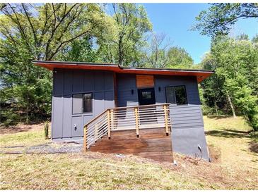 Modern home with a unique gray exterior, wood accents, and a charming wooden deck and railing at 1092 Hillcrest Se Dr, Atlanta, GA 30316