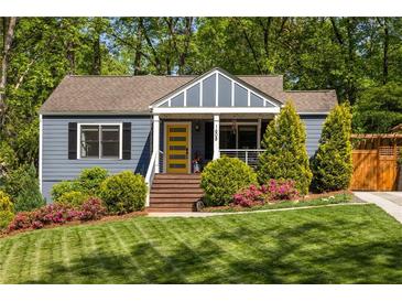 Charming home with manicured lawn, colorful flowerbeds, and a bright yellow door at 1608 Terry Mill Se Rd, Atlanta, GA 30316