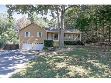 Charming home featuring a well-maintained front yard, covered porch, and attached two-car garage at 304 N Briar Rdg, Woodstock, GA 30189