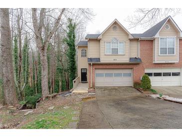 Inviting townhome showcasing a well-manicured lawn, attached garage, and neutral siding at 873 Edgewater Cir, Marietta, GA 30062