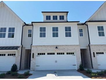 Charming home featuring a wide two-car garage and classic architectural details at 2405 Malster Ln, Lawrenceville, GA 30043