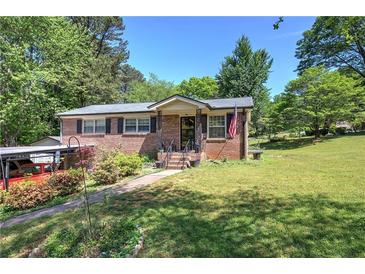Charming brick home with a well-maintained lawn, mature trees, and inviting front porch at 1001 Rhett Nw Dr, Kennesaw, GA 30144