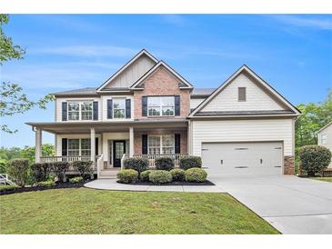 Beautiful two-story home features a landscaped yard, covered front porch, and two car garage at 881 Springs Crest Dr, Dallas, GA 30157