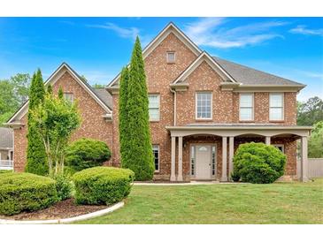 Charming brick two-story home with manicured lawn and mature landscaping at 900 Fox Croft Pl, Canton, GA 30114