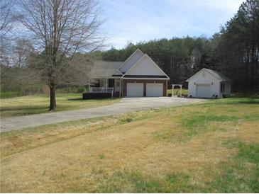 Charming home featuring a two-car garage, a detached garage and a well-maintained front yard at 28 County Line #2 Rd, Rydal, GA 30171
