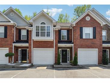 Charming brick townhouse with attached garage and well-maintained front yard at 215 Morris Ln, Woodstock, GA 30188