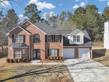 Charming two-story brick home features a two-car garage, manicured lawn, and classic curb appeal at 5854 Cobalt Dr, Powder Springs, GA 30127
