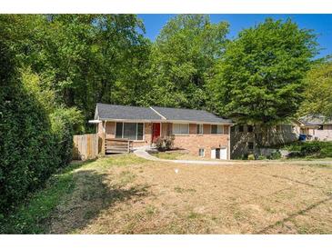 Charming single-story brick home with a well-maintained lawn and mature trees in a desirable neighborhood at 474 Waterford Nw Rd, Atlanta, GA 30318