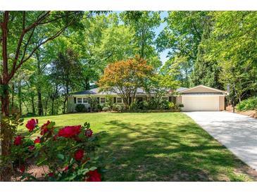 Charming single-story home with a well-manicured lawn and mature trees providing ample shade at 2620 Margaret Mitchell Dr, Atlanta, GA 30327