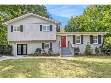 Charming two-story home with a manicured lawn, black shutters, and a vibrant red front door at 3995 Emerald North Dr, Decatur, GA 30035