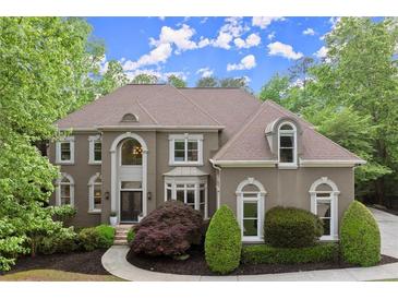 Elegant two-story home with a manicured lawn and mature landscaping at 770 Pine Leaf Ct, Alpharetta, GA 30022