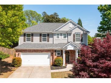 Charming two-story home with brick and siding, a well-manicured lawn, and an attached two-car garage at 101 Magnolia Creek Dr, Canton, GA 30115