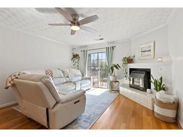 Inviting living room featuring a ceiling fan, fireplace, a sliding door, and stylish decor at 970 Sidney Marcus Ne Blvd # 2408, Atlanta, GA 30324