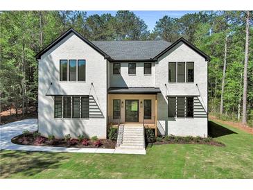 Beautiful two-story brick home with a manicured lawn and lush trees in a serene neighborhood at 191 Darwish Dr, Mcdonough, GA 30252
