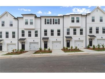 Modern townhouse exterior features a white facade, black accents, and single-car garages at 3145 Washburn Sw St, Atlanta, GA 30354