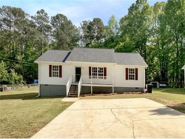 Charming single-story home with a well-maintained lawn, complemented by a concrete driveway and mature trees at 45 Carroll St, Temple, GA 30179