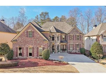 Stunning brick and stone home featuring a symmetrical facade, manicured landscaping, and a spacious driveway at 4802 Moon Chase Dr, Buford, GA 30519