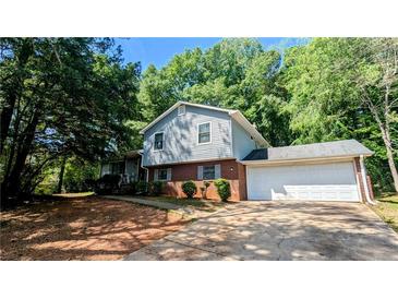 Charming two-story home featuring a brick facade, light siding, and a spacious two car garage at 4402 Sebring Walk, Decatur, GA 30034
