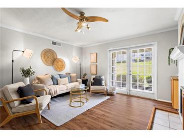 Bright living room featuring stylish furnishings, hardwood floors, and sliding glass doors to bring in natural light at 1150 Collier Nw Rd # E3, Atlanta, GA 30318