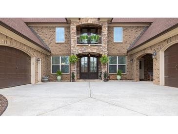 Elegant brick home with a stone-accented entrance and a spacious driveway leading to attached garages at 401 Sara Ct, Loganville, GA 30052