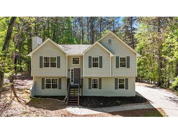 Charming home with light siding, green shutters, and a neatly landscaped front yard with mature trees at 257 Browning Cir, Acworth, GA 30101