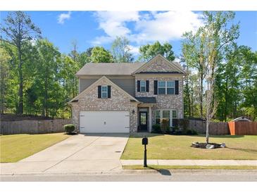 Charming brick front exterior with a well-maintained lawn and two-car garage at 4150 Spring Ridge Dr, Cumming, GA 30028