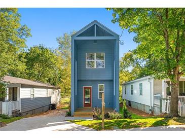 Charming blue two-story home with inviting front porch nestled among lush green trees on a sunny day at 281 Griffin Nw St, Atlanta, GA 30314