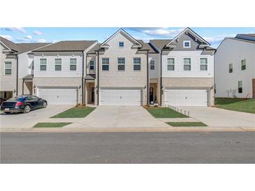 Charming townhomes with white brick, attached garages, and well-manicured lawns offer modern living at 8214 Tiger Way, Riverdale, GA 30296