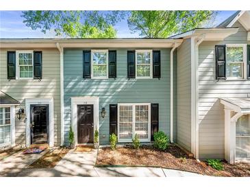 Charming two-story townhouse with black shutters and manicured landscaping at 113 Courtyard Ter, Roswell, GA 30075