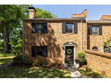Charming brick townhome featuring black shutters, an inviting front door and a manicured lawn at 266 Adair St, Decatur, GA 30030