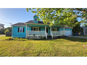 Charming blue cottage-style home with a welcoming front porch and landscaped lawn at 3065 Ashly Pines Dr, Snellville, GA 30078