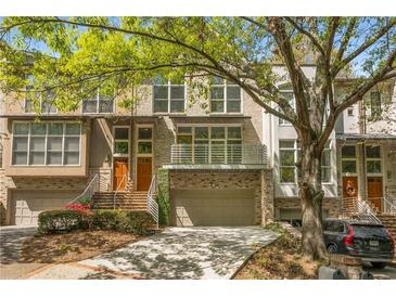 Charming townhome with a brick facade, attached garage, and well-manicured landscaping at 1290 Fernwood Ne Cir, Brookhaven, GA 30319