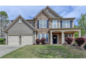 Charming two-story home with a stone facade, manicured lawn, and a two-car garage at 4280 Azurite St, Cumming, GA 30040