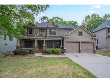 Charming two-story home boasts a manicured lawn, covered porch, and a two-car garage at 429 Gold Xing, Canton, GA 30114