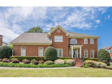 Beautiful two-story brick home with manicured front yard and mature landscaping at 1655 Holly Lake Cir, Snellville, GA 30078