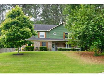Charming two-story home featuring a covered front porch, manicured lawn, and mature trees offering curb appeal at 3987 Ivory Gables Pl, Buford, GA 30519
