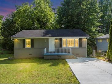 Charming home featuring a well-maintained lawn, gray painted brick foundation and concrete driveway at 1677 Wayland Ne Cir, Brookhaven, GA 30319