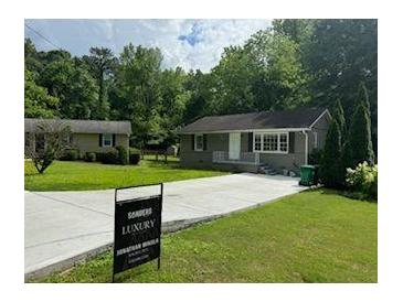 Charming home features a lush front yard, long driveway, and well-maintained exterior at 1677 Wayland Ne Cir, Brookhaven, GA 30319