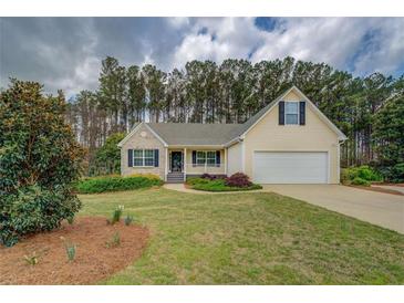 Charming home with a manicured lawn, landscaping, and a two-car garage at 116 Laurel Ln, Social Circle, GA 30025