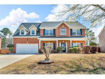 Charming two-story red brick home with a well-manicured lawn and attached two-car garage at 362 Interlake Pass, Mcdonough, GA 30252
