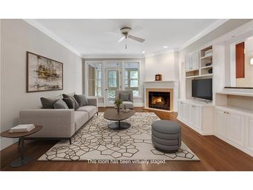 Bright living room boasts a fireplace, built-in shelving, and hardwood floors at 1020 Riverside Rd, Roswell, GA 30076