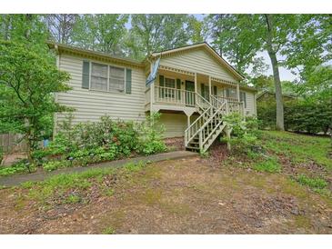 Charming home with a quaint front porch, complemented by lush landscaping and a welcoming walkway at 408 Walnut Dr, Woodstock, GA 30189