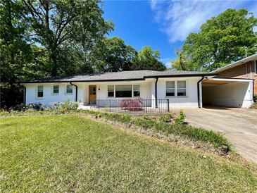 Charming one-story white brick home with a well-maintained lawn, inviting curb appeal, and attached carport at 2682 Pineland Ave, Atlanta, GA 30340