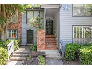 Charming townhouse exterior featuring well-maintained landscaping and a welcoming entryway with brick accents at 1244 Weatherstone Ne Dr, Atlanta, GA 30324