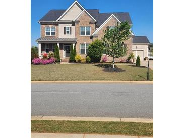 Beautiful brick two-story home boasts a manicured lawn, colorful flower beds and a welcoming entrance at 134 Sierra Cir, Woodstock, GA 30188