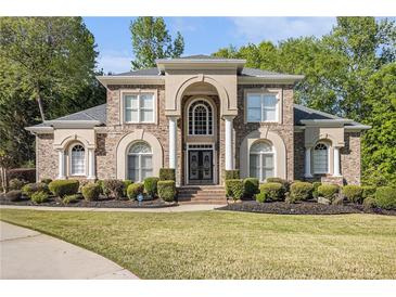 Beautiful two-story brick home with manicured lawn and an arched entryway with double doors at 4855 Regency Sw Trce, Atlanta, GA 30331