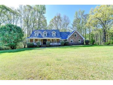 Charming brick home featuring a covered front porch and expansive, well-manicured lawn at 5800 S Richland Creek Rd, Buford, GA 30518