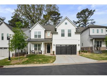 Charming two-story home featuring white siding, black trim, inviting front porch, and a two-car garage at 763 Arrendale Dr, Marietta, GA 30064